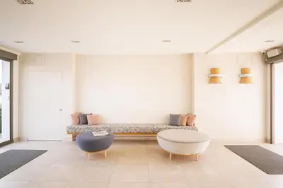 a living room with a couch and two chairs at Apartamentos Marfina in Castelldefels