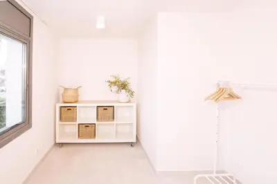 a white room with a shelf and a window at Apartamentos Marfina in Castelldefels
