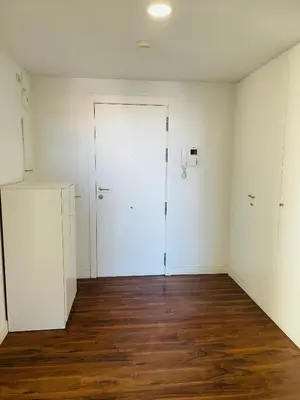 an empty room with a white door and wooden floors at Fira de Barcelona City View Apartment with Garage Parking in Hospitalet de Llobregat