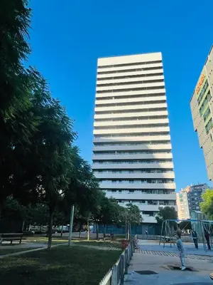 a tall white building with a park in front of it at Fira de Barcelona City View Apartment with Garage Parking in Hospitalet de Llobregat