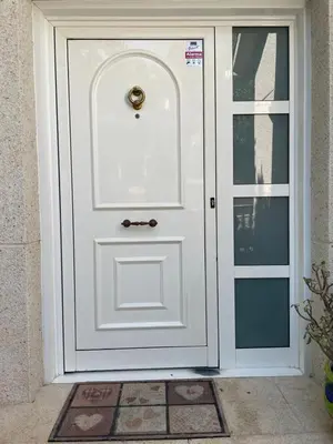 a white door with a gold knocker on it at Sunny forest Villa near Barcelona in Vallirana