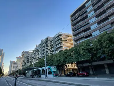 a blue bus on a city street with tall buildings at Standing Apartment Barcelona Forum in Sant Adria de Besos