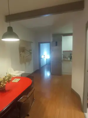 a living room with a red table and a kitchen at SWEET APARTMENT IN GRACIA DISTRICT! in Barcelona