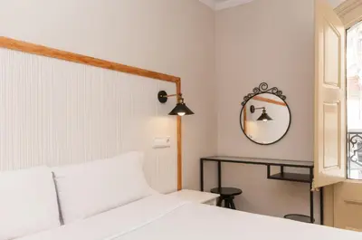 a bedroom with a white bed and a mirror at Homenfun Barcelona Eixample I in Barcelona