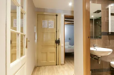a bathroom with a sink and a toilet and a door at Homenfun Barcelona Eixample I in Barcelona