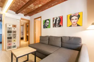 a living room with a couch and pictures on the wall at Homenfun Barcelona Eixample I in Barcelona