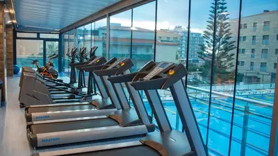 a row of treadmills next to a swimming pool at Sant Jordi Boutique Hotel in Calella