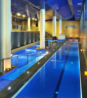 a large swimming pool with blue lights in a building at Sant Jordi Boutique Hotel in Calella