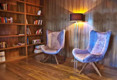 two blue chairs in a room with a book shelf at Sant Jordi Boutique Hotel in Calella