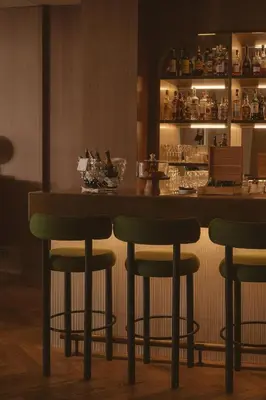 a bar with green bar stools in a restaurant at Hotel Regina Barcelona in Barcelona