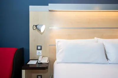 a bedroom with a bed and a phone on a table at Holiday Inn Express Barcelona - Montmeló by IHG in Granollers