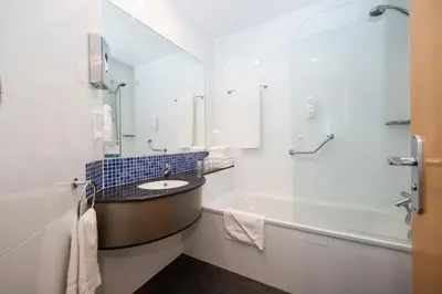 a white bathroom with a sink and a tub at Holiday Inn Express Barcelona - Montmeló by IHG in Granollers