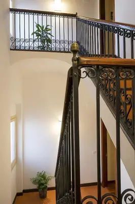 a staircase with a black railing in a house at Hotel Palou 1874 in Sant Pere de Ribes
