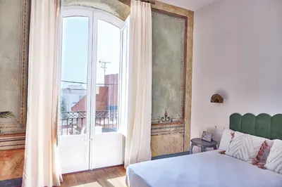 a bedroom with a bed and a large window at Hotel Palou 1874 in Sant Pere de Ribes