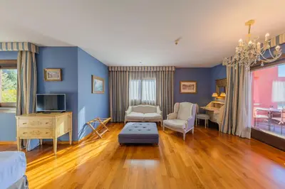 a living room with blue walls and wooden floors at Hotel Blancafort Spa Termal in La Garriga