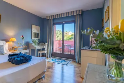 a bedroom with a bed and a door to a balcony at Hotel Blancafort Spa Termal in La Garriga