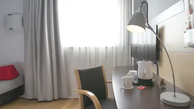 a desk with a lamp and a computer on it at Holiday Inn Express Molins de Rei by IHG in Molins de Rei