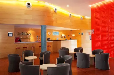 a restaurant with tables and chairs and a bar at Holiday Inn Express Molins de Rei by IHG in Molins de Rei