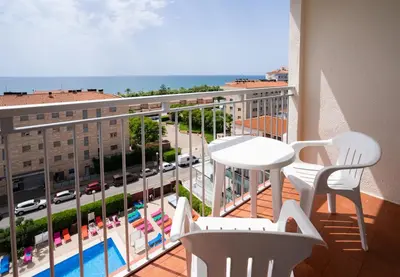 a balcony with a view of a pool and a table and chairs at Medplaya Hotel Santa Monica in Calella