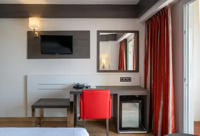 a bedroom with a desk and a red chair at Medplaya Hotel Santa Monica in Calella
