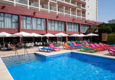 a pool in front of a hotel with chairs and tables at Medplaya Hotel Santa Monica in Calella
