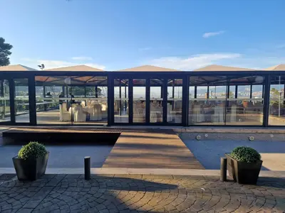 a pavilion with a wooden boardwalk and some plants at Hotel El Castell in Sant Boi del Llobregat