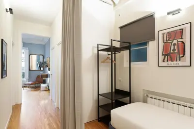 a bedroom with a black book shelf next to a bed at Señor Urgell Apartment by Olala Homes in Barcelona