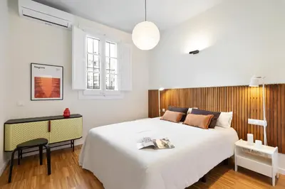a bedroom with a large white bed and a desk at Señor Urgell Apartment by Olala Homes in Barcelona