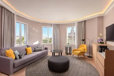 a living room with a couch and a tv at Le Meridien Barcelona in Barcelona