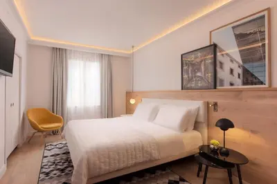a hotel room with a bed and a chair at Le Meridien Barcelona in Barcelona