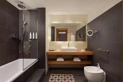 a bathroom with a sink and a toilet and a shower at Le Meridien Barcelona in Barcelona