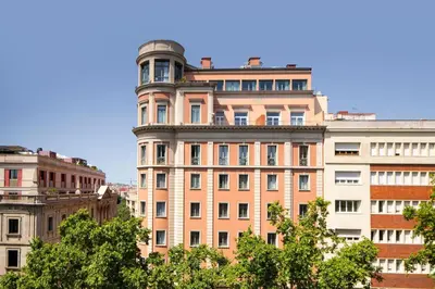 a tall building with a tower on top of it at Le Meridien Barcelona in Barcelona
