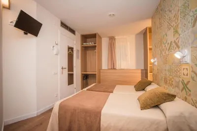 a bedroom with a bed and a tv on a wall at Hostal Marenostrum in Barcelona