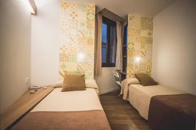 a hotel room with two beds and a window at Hostal Marenostrum in Barcelona