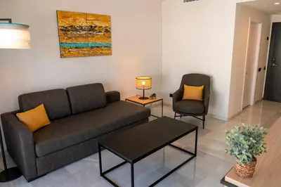 a living room with a couch and two chairs at URH Sitges Playa in Sitges