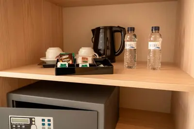 two bottles of water on a shelf next to a coffee maker at URH Sitges Playa in Sitges