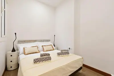a white bedroom with a large bed with pillows at Bright Apt with Private Terrace in Sant Antoni in Barcelona
