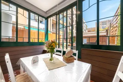 a dining room with a table with a vase of flowers at Bright Apt with Private Terrace in Sant Antoni in Barcelona