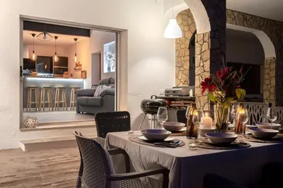 a dining room with a table and a living room at Les Terrasses de la Cisa, 20kms de BCN in Premia de Dalt