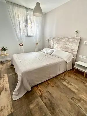 a bedroom with a large bed with a wooden floor at Les Terrasses de la Cisa, 20kms de BCN in Premia de Dalt
