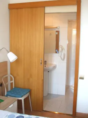 a bathroom with a toilet and a sink and a door at Hostal Felipe 2 in Barcelona