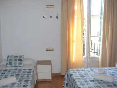 a small room with two beds and a window at Hostal Felipe 2 in Barcelona