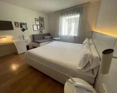 a bedroom with a large white bed and a couch at Pol & Grace Hotel in Barcelona