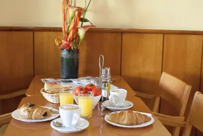 a table with plates of food and cups of orange juice at Hotel Ciutat De Sant Adria in Sant Adria de Besos