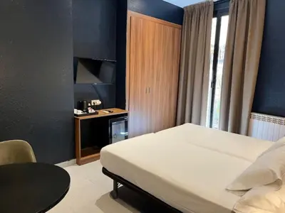 a bedroom with a large bed with a blue wall at Hotel Aneto in Barcelona