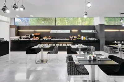 a restaurant with tables and chairs and a counter at Ikonik Anglí in Barcelona
