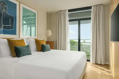 a bedroom with a large white bed and a large window at Sabàtic Gavà Mar, Barcelona, a Tribute Portfolio Hotel in Gavà