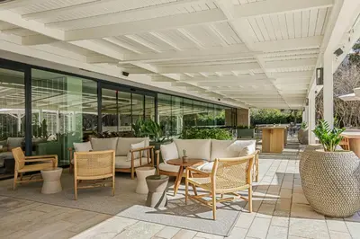 an outdoor patio with chairs and tables and windows at Sabàtic Gavà Mar, Barcelona, a Tribute Portfolio Hotel in Gavà