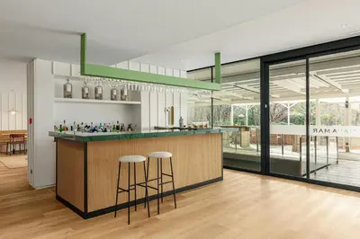 a kitchen with a counter and stools in a room at Sabàtic Gavà Mar, Barcelona, a Tribute Portfolio Hotel in Gavà