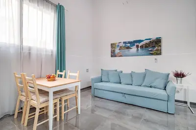 a living room with a blue couch and a table at Magic Badalona House in Badalona
